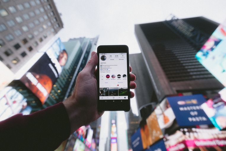 smart phone open to social media surrounded by billboards